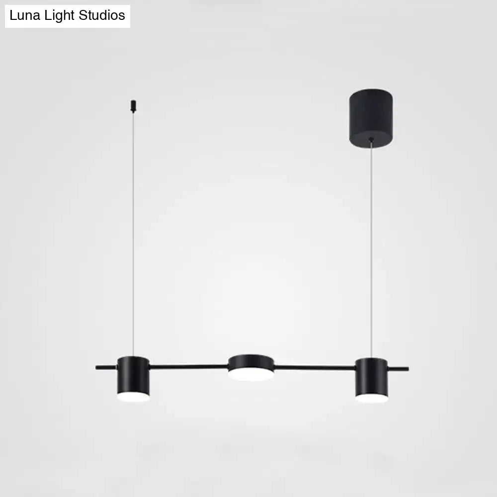 Modern black and gold ceiling light fixture with three minimalist cylindrical pendant lights for kitchen island use