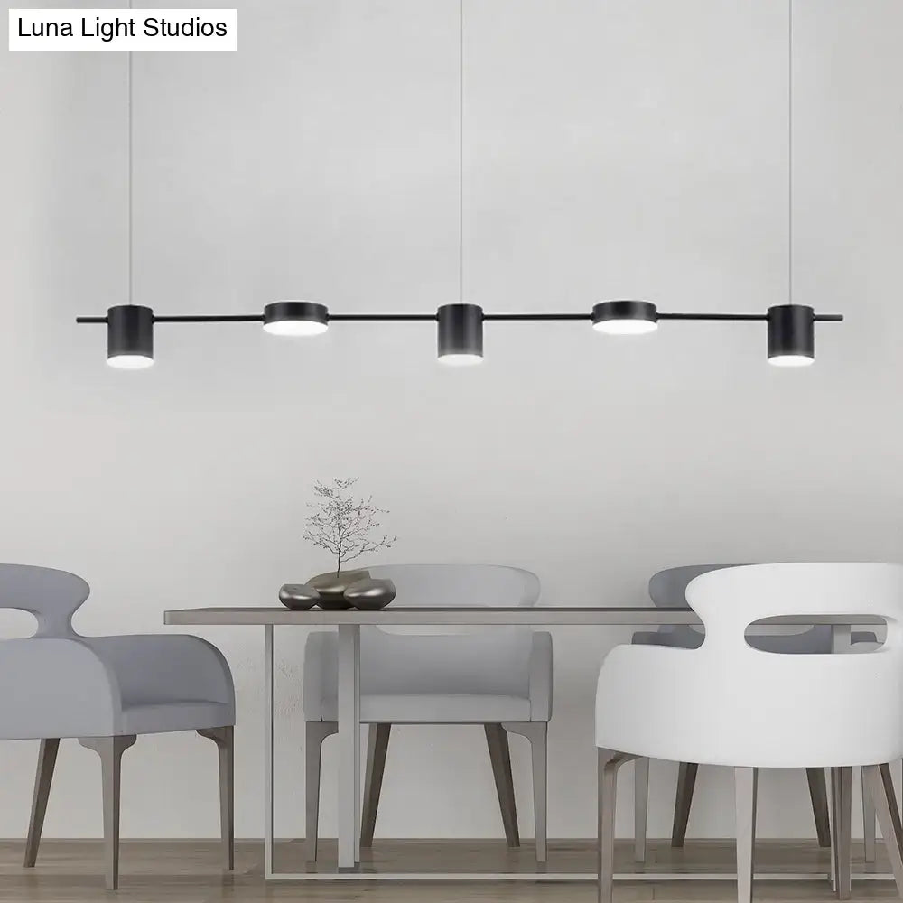 Modern black and gold cylindrical pendant light fixture ceiling light fixture in minimalist dining room setting