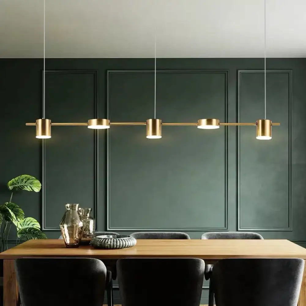Modern black gold ceiling light fixture with four cylindrical bulbs and thin cord suspension for kitchen island lighting