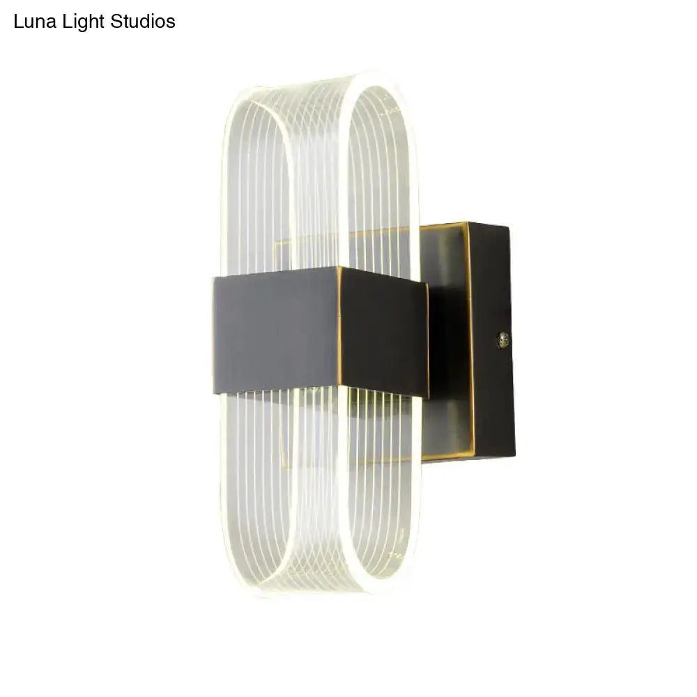 Modern black and gold led sconce light featuring a curved translucent acrylic body with vertical ridges for bedroom wall mount