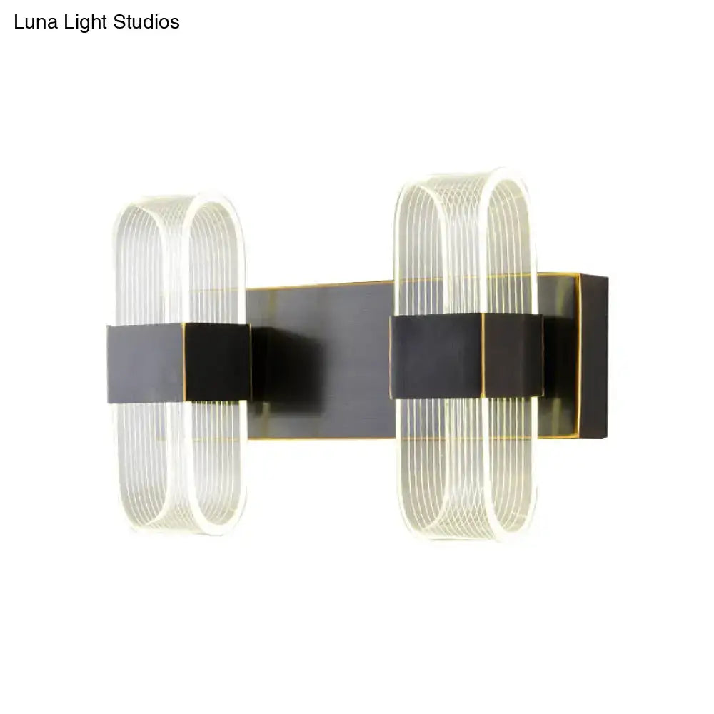 Modern black and gold led sconce light with dual arms, black matte metal frame, and clear ribbed glass shades for bedroom wall mount