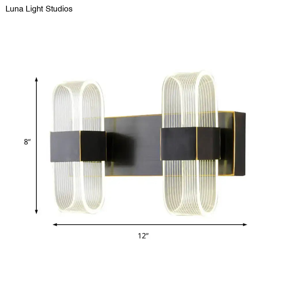 Modern black and gold dual-armed sconce light with frosted glass tubes and brass accents for bedroom wall mount