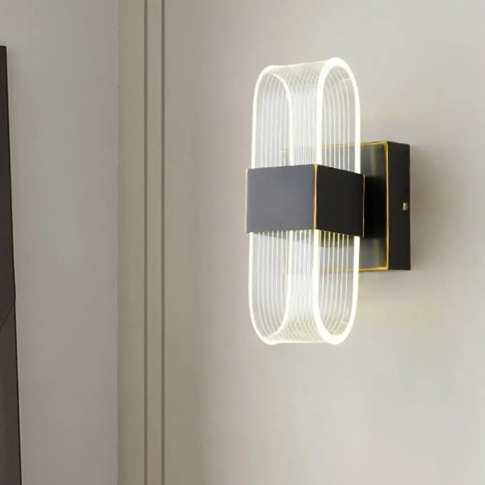 Modern black and gold led sconce light with sleek frame and oval glass diffuser for bedroom wall mount lighting