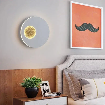 Modern black and gold led wall lights circular sconce with sleek gray finish and glowing golden textured center by decorbites