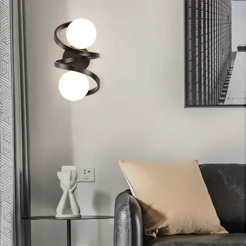 Modern black metal wall sconce with two glowing white spherical bulbs for bedroom decor featuring led wall lights decorbites black copper