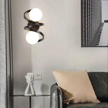 Modern black metal wall sconce with two glowing white spherical bulbs for bedroom decor featuring led wall lights decorbites black copper