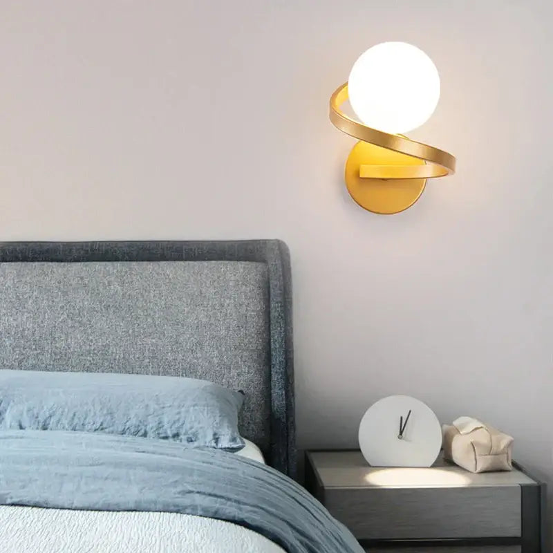 Modern black and gold led wall light with gold-toned curved arms and spherical white glass bulb by decorbites black copper