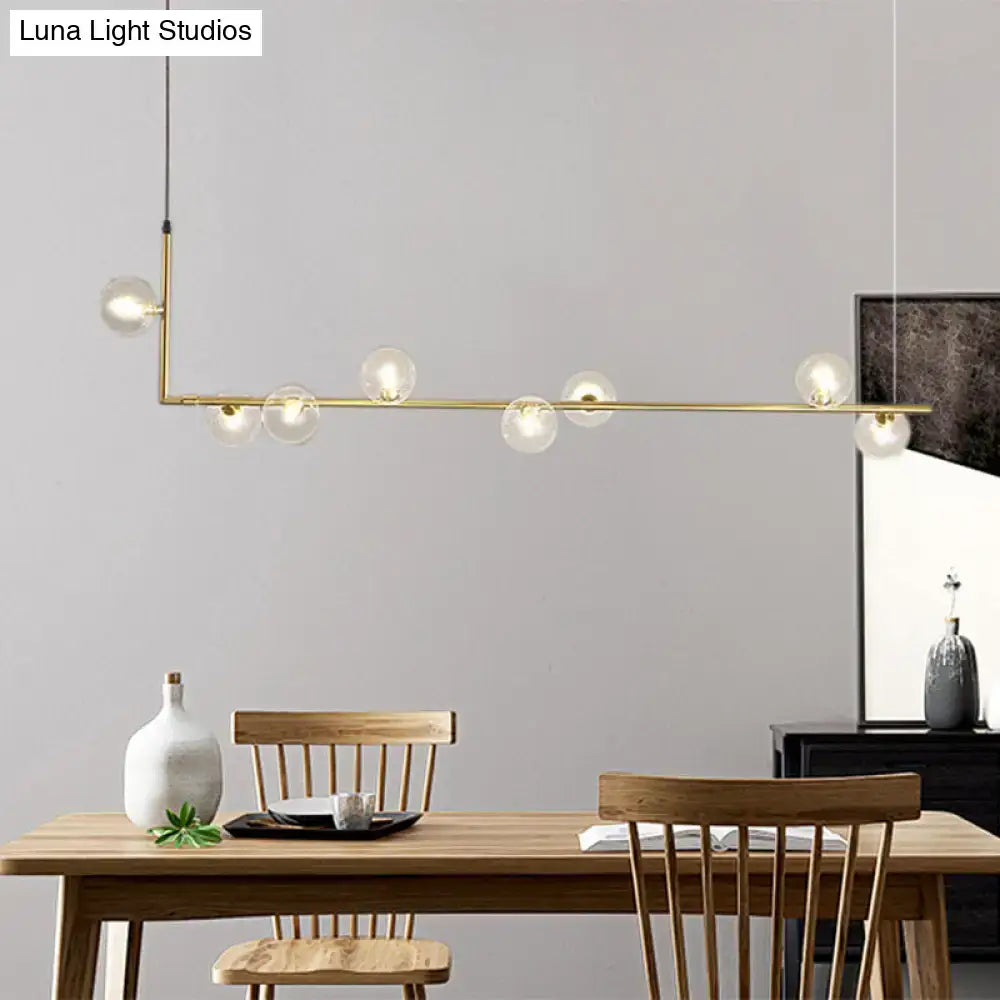 Modern black gold linear chandelier with gold-toned frame and clear glass globe bulbs for dining room island lighting