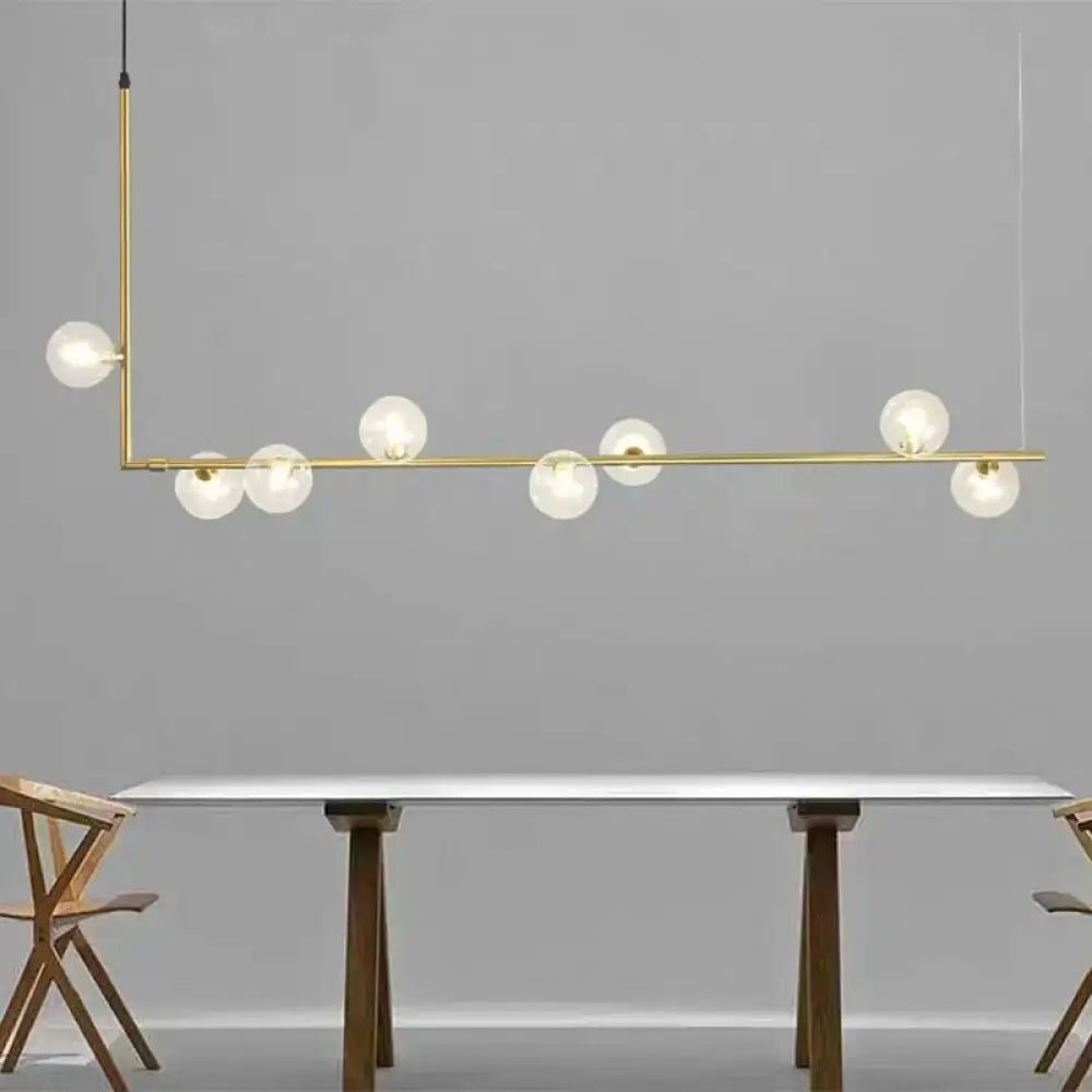 Modern black gold linear chandelier featuring a brass pendant light with seven frosted glass globe bulbs in an asymmetrical design