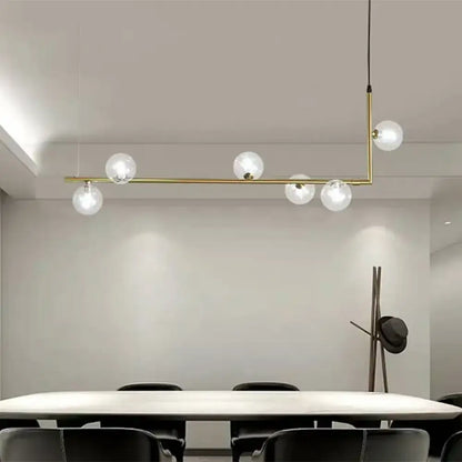 Modern black gold linear chandelier with five clear glass globe bulbs in a brass pendant light design for dining rooms