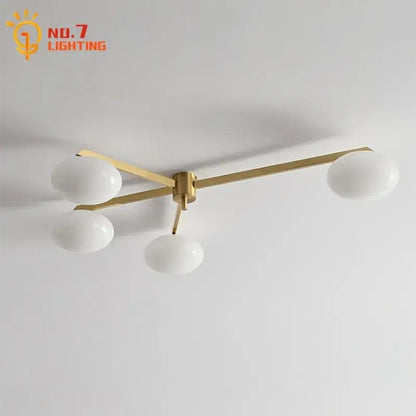 Modern black and gold lustre ceiling light fixture with brass finish and four frosted glass globes for kitchen use