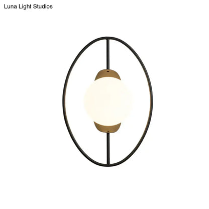 Modern black and gold metal halo ring wall lamp with white glass and warm brass accents for bedroom lighting
