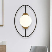 Modern oval wall lamp with black and gold metal halo ring frame and white glass globe for bedroom lighting