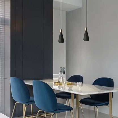 Deep blue velvet dining chairs with gold-tone metal legs complement modern black metal pendant chandelier decorbites black metal