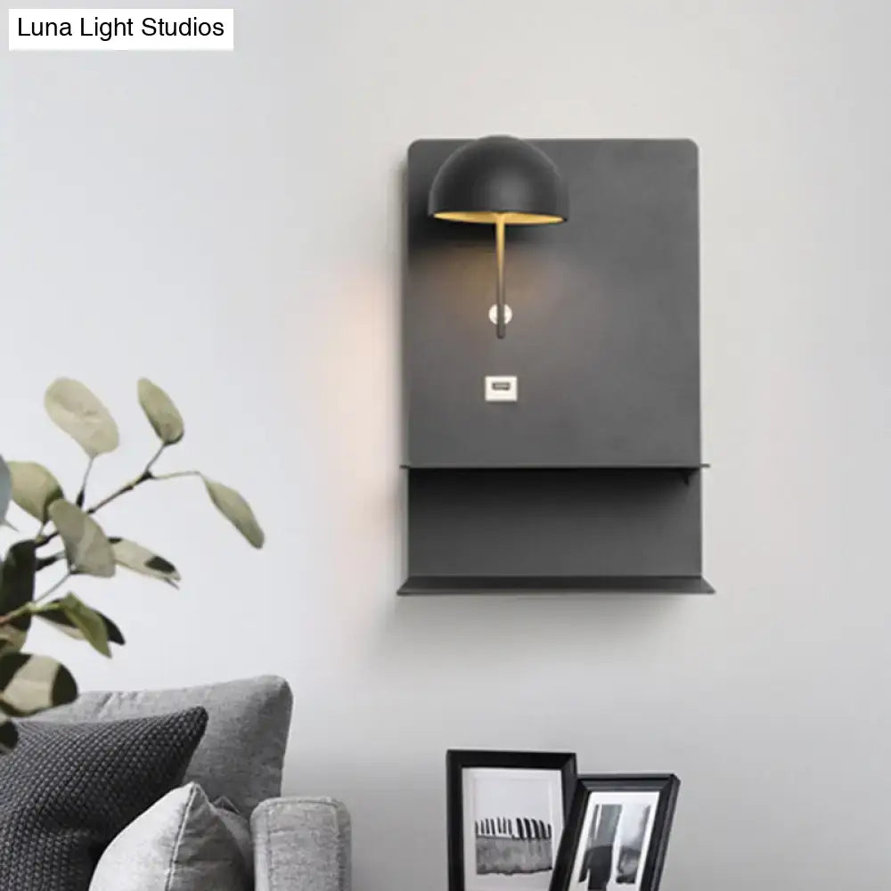 Modern metal wall sconce in black and gold with dome shade and integrated usb port for living room use