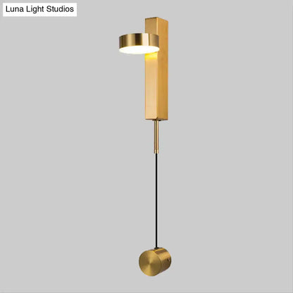 Modern black and gold metallic flush mount wall sconce with cylindrical light head and hanging spherical base for bedroom lighting