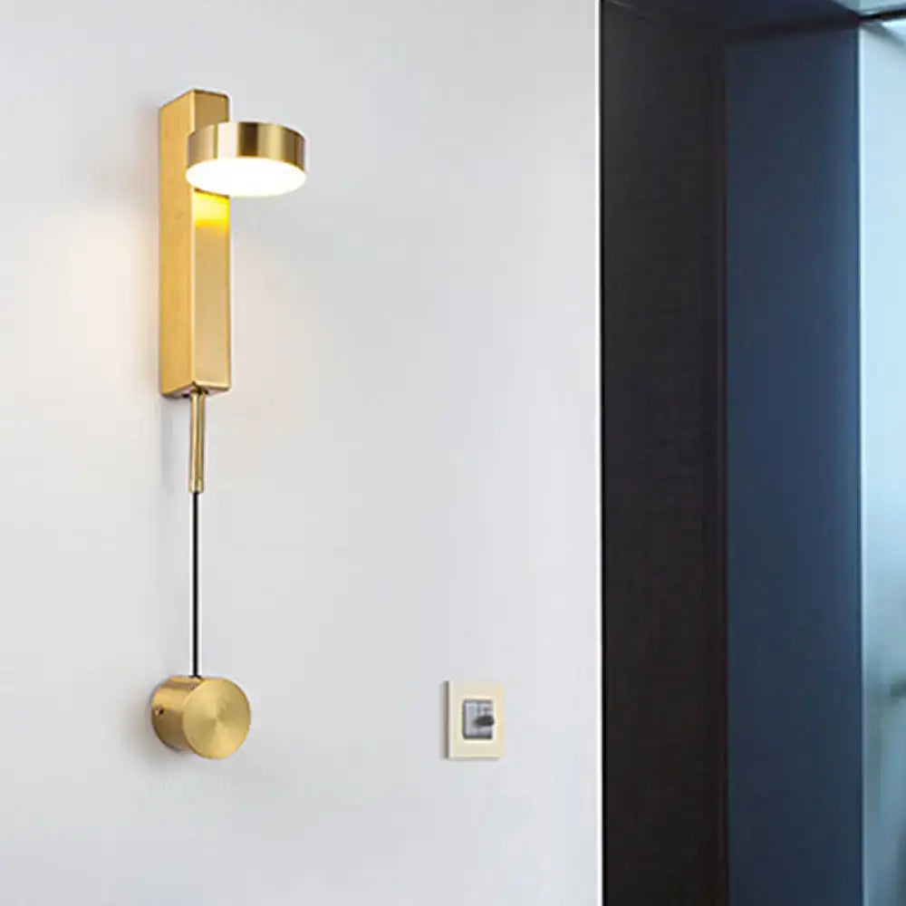 Gold-colored metallic wall lighting flush mount wall sconce with sleek rectangular body and cylindrical base for bedroom use