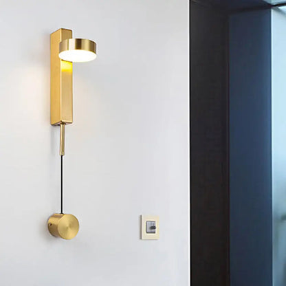 Gold-colored metallic wall lighting flush mount wall sconce with sleek rectangular body and cylindrical base for bedroom use
