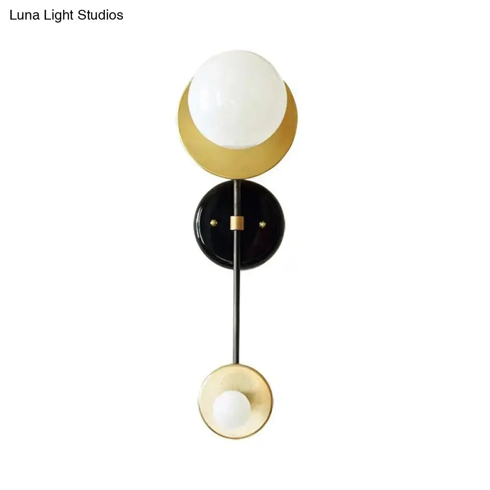 Modern black and gold wall sconce with milky glass frosted globe shades for bedroom reading lamp lighting