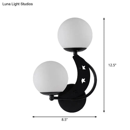 Modern black wall lamp with crescent moon shape, star cutouts, and two milky glass ball shades for bedroom use