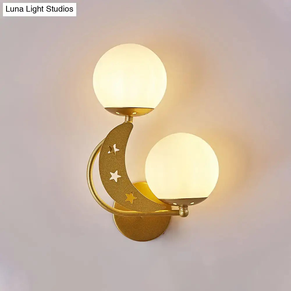 Gold-toned crescent moon wall lamp with milky glass ball shades and star cutouts for modern bedroom lighting
