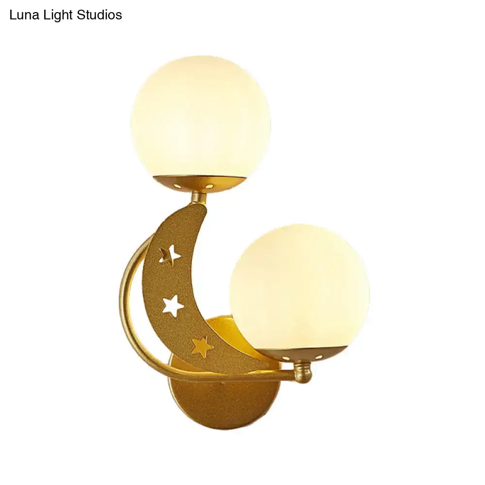 Gold-toned crescent moon wall lamp with star cutouts and two milky glass ball frosted shades for bedroom lighting