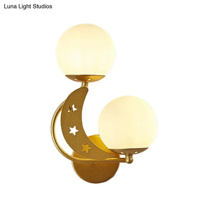 Gold-toned crescent moon wall lamp with star cutouts and two milky glass ball frosted shades for bedroom lighting
