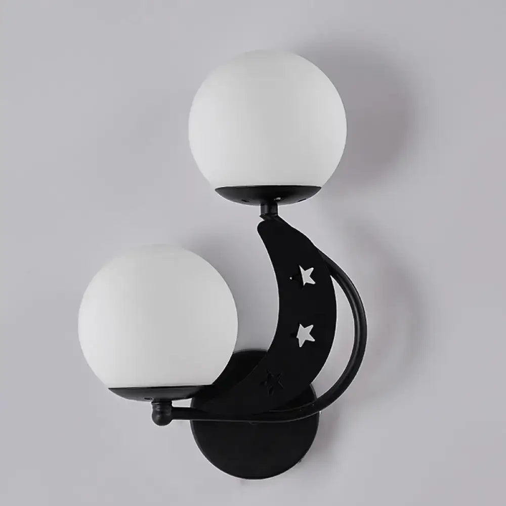 Modern black crescent wall lamp with milky glass ball shades and star cutouts for elegant bedroom lighting