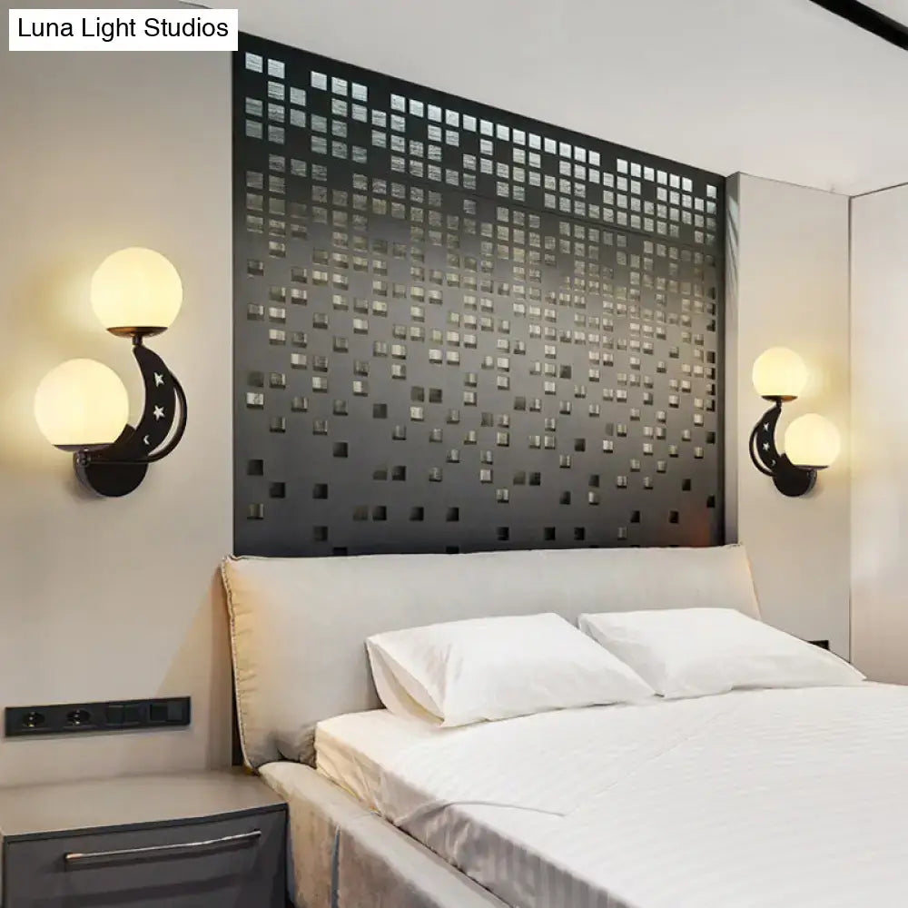 Modern black and gold wall lamp with moon and star motifs featuring milky glass ball shades for bedroom lighting