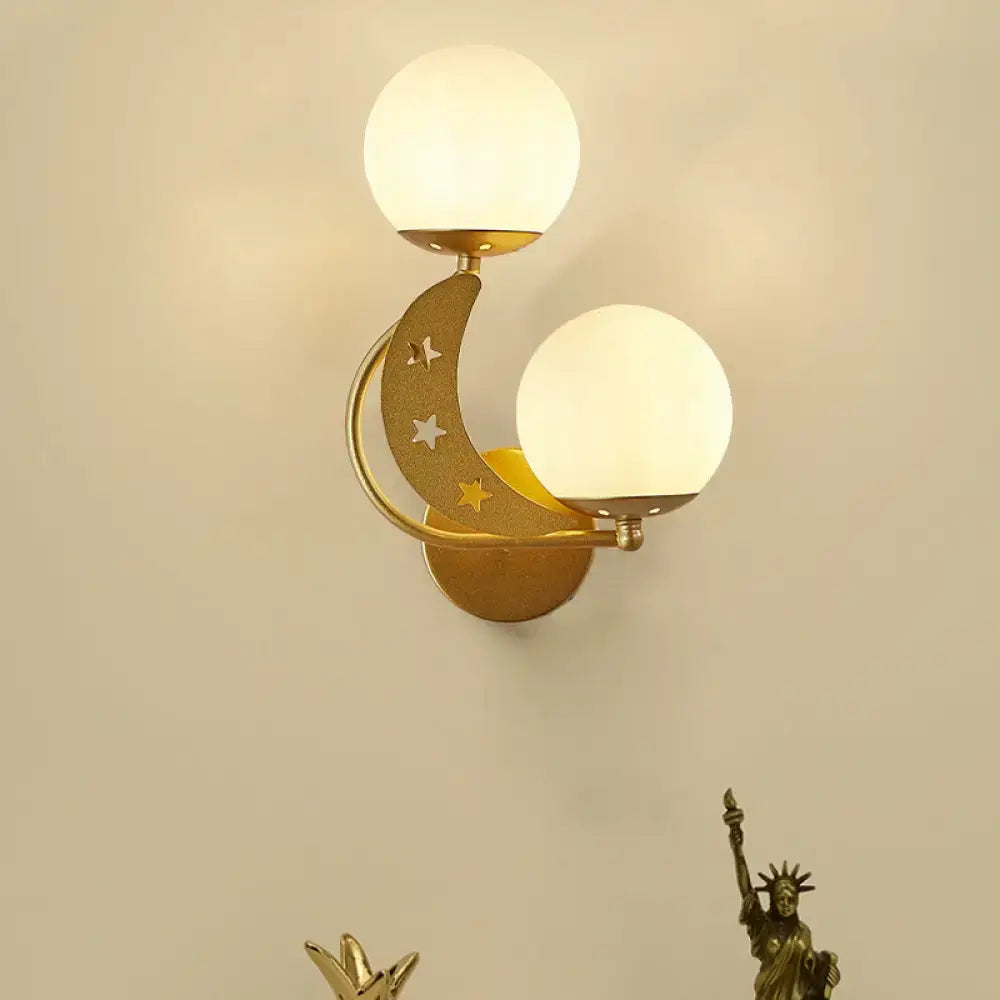 Gold-toned crescent moon wall lamp with milky glass ball shades and star cutouts for modern bedroom lighting