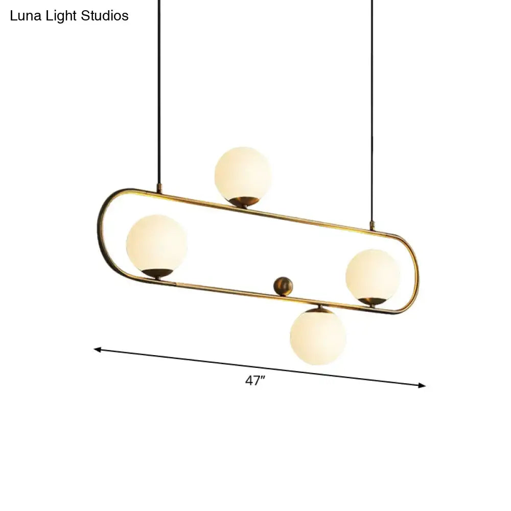 Modern brass-finished pendant light with four frosted opal glass globes in black gold oval frame for dining room lighting