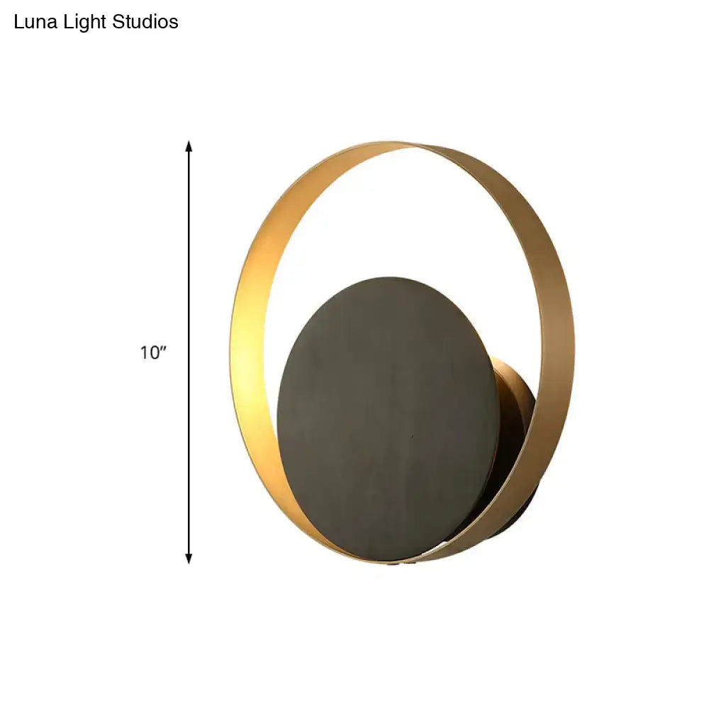 Modern black and gold orbit sconce light featuring a gold-toned circular metallic orbit sconce with matte black disc