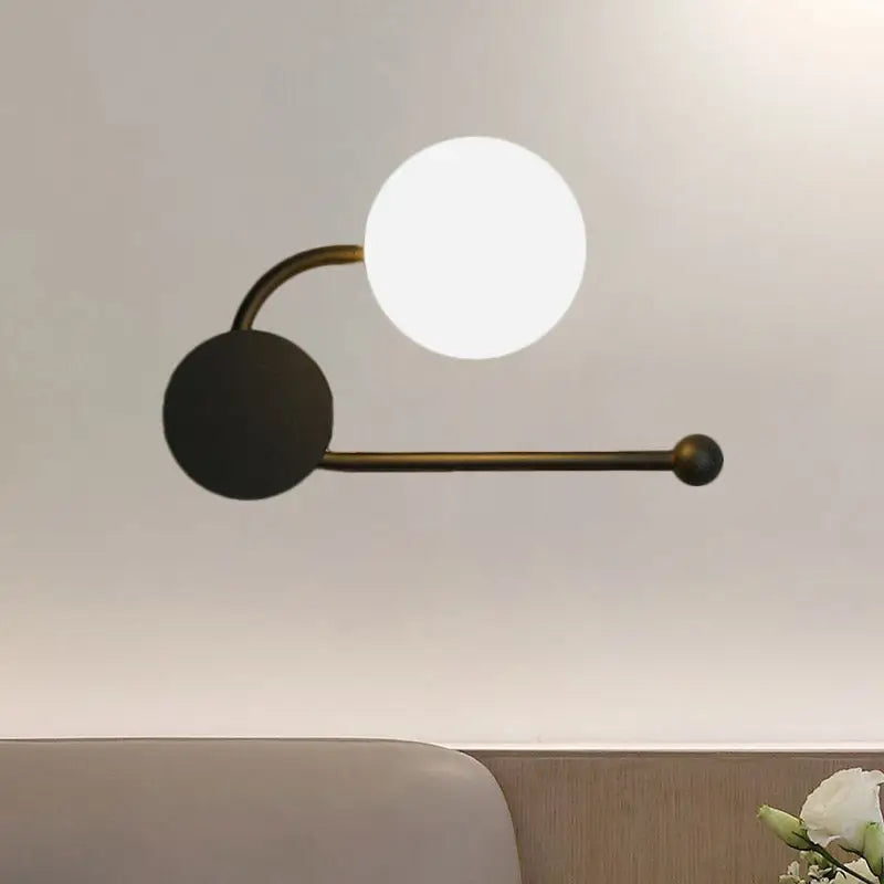 Modern black and gold planter sconce with matte black base, curved brass arm, and frosted glass shade for 110v-120v use