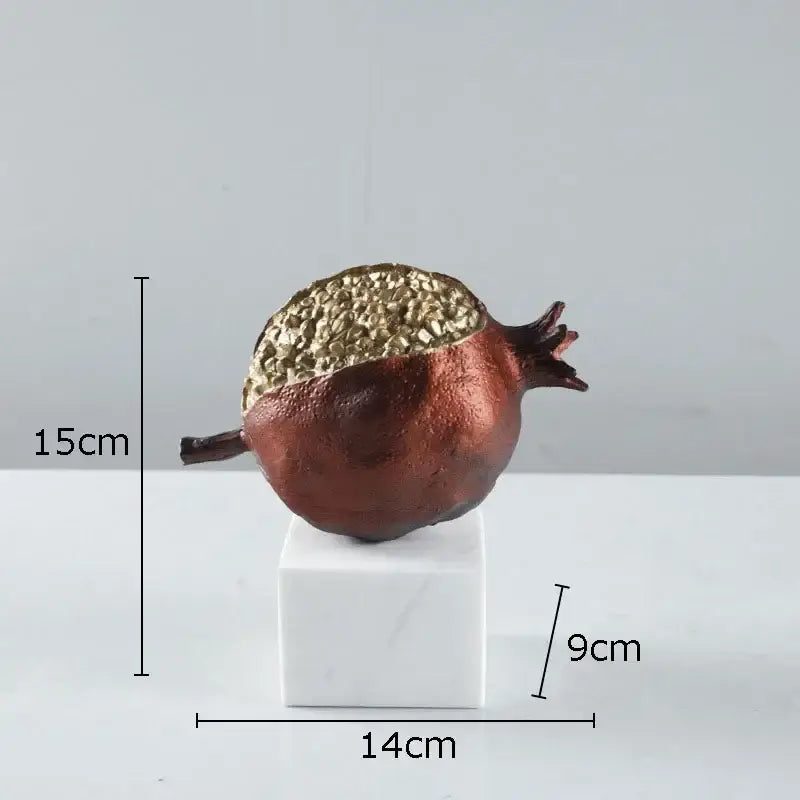 Modern black and gold pomegranate sculpture with textured metallic gold top and matte copper body on white marble base decorbites golden pomegranate