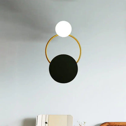 Modern black and gold round wall sconce with direct wired electric connection featuring a gold round wall frame and spherical shades