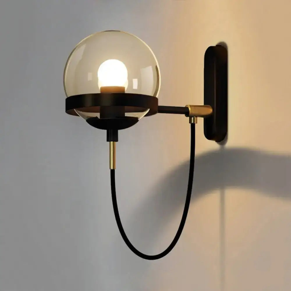 Modern black gold wall lamp with smoke glass globe and brass accents for stylish living room lighting