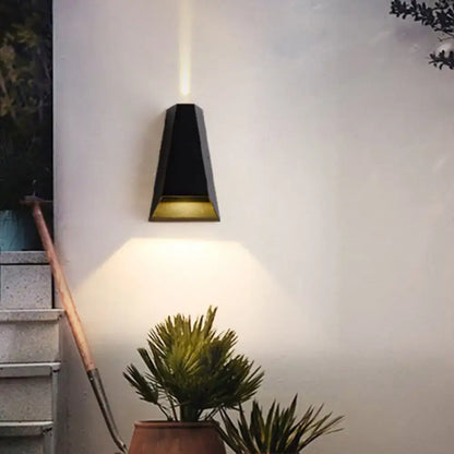 Modern black and gold geometric led wall light with warm white light and downward-facing beam for bedroom use