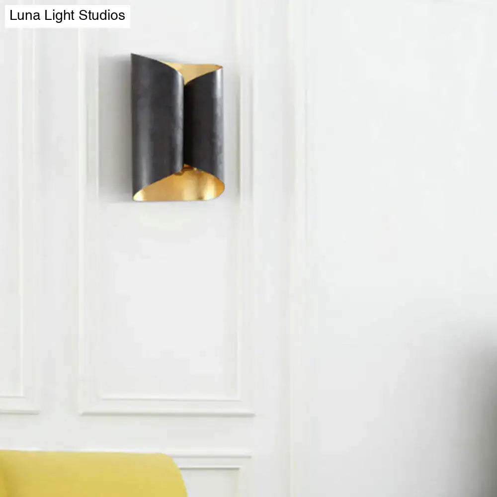 A modern black and gold twisted light fixture porch wall sconce with a sleek curved design and bulb base compatibility