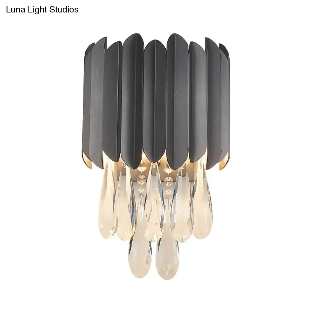 Modern black metal leaf-shaped wall lamp with clear crystal teardrop pendants for elegant bedroom lighting