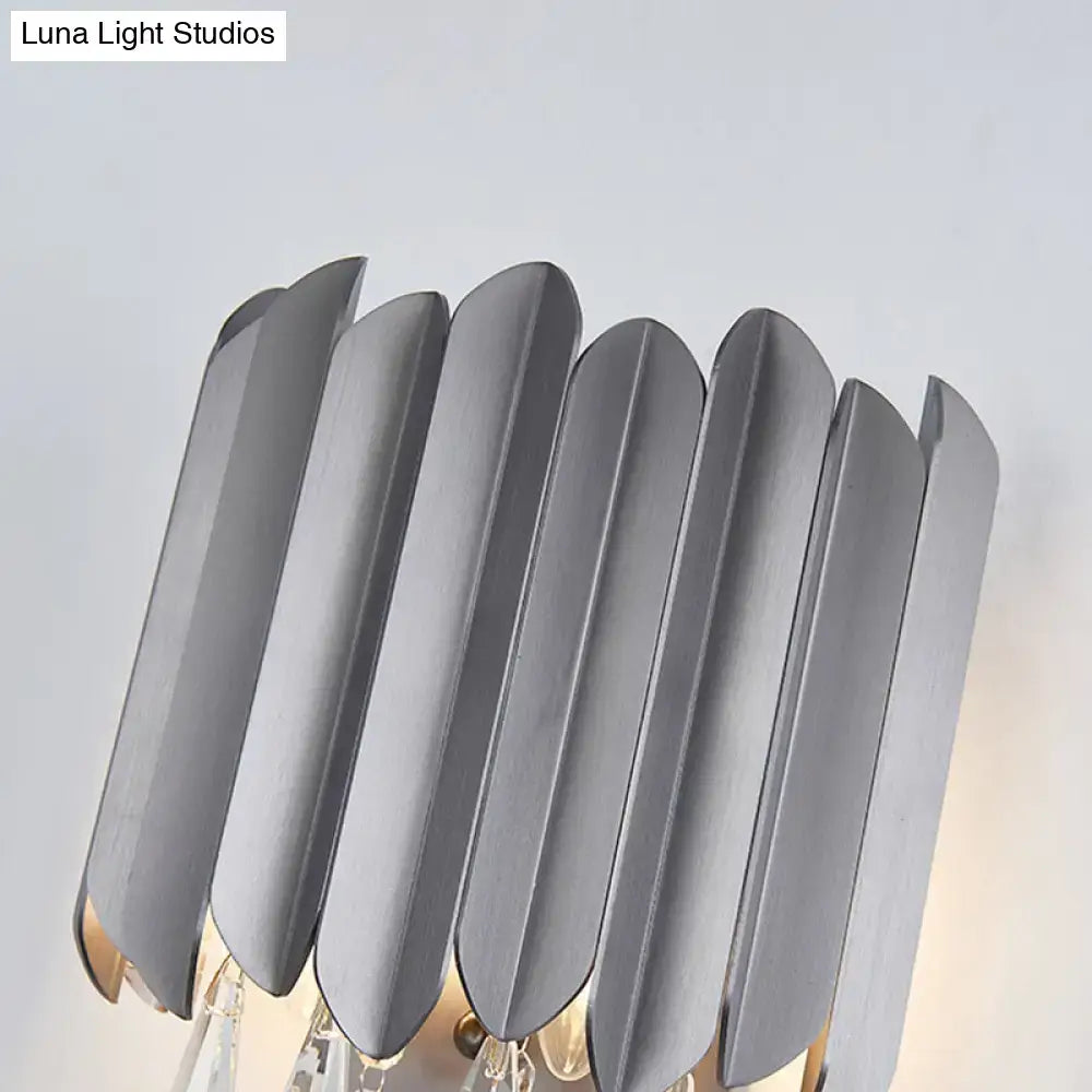 Modern gray metallic wall lamp with sleek overlapping leaf panels and a warm glow, featuring clear crystal teardrop accents