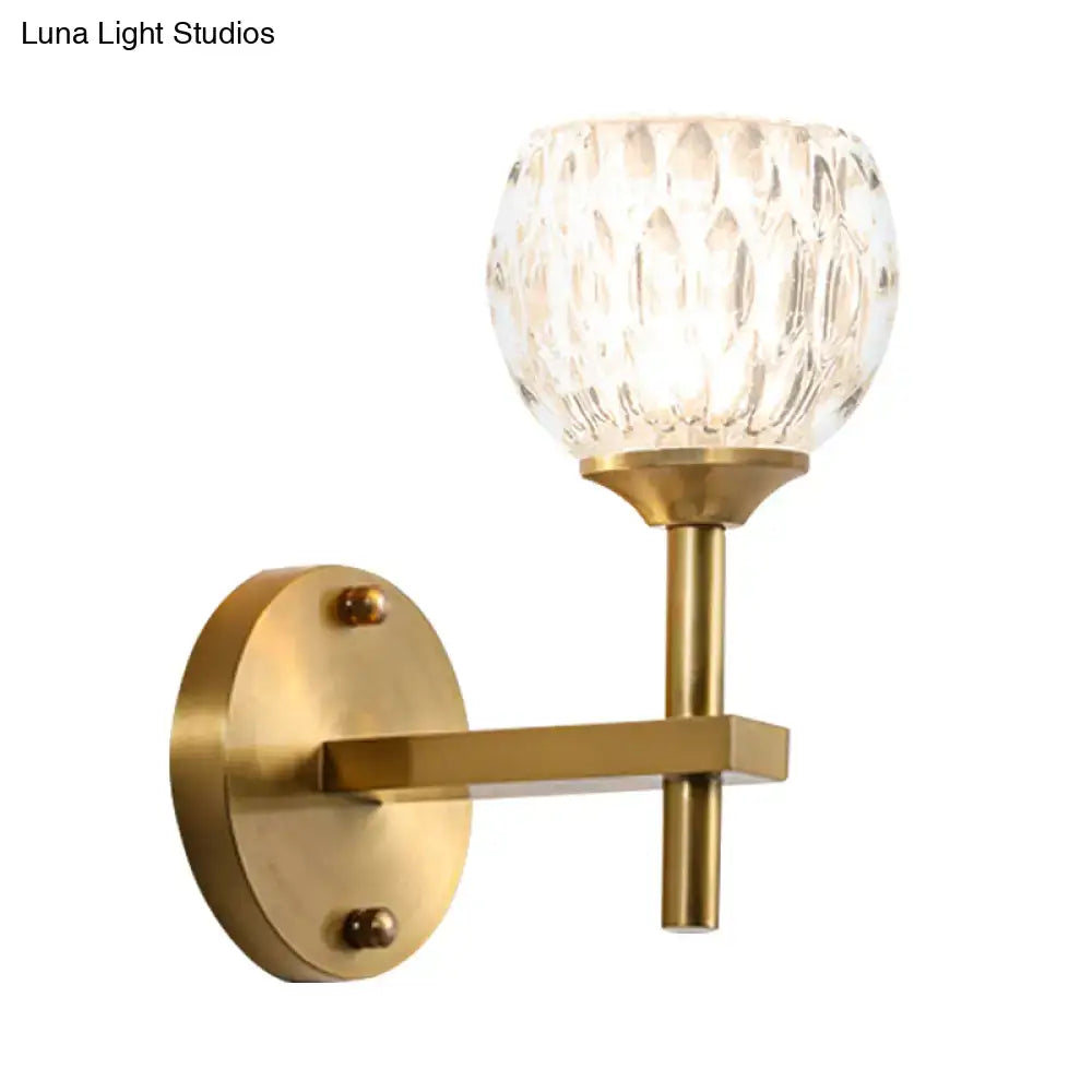 Modern black and gold wall light with brass finish and faceted crystal dimpled glass for living room illumination