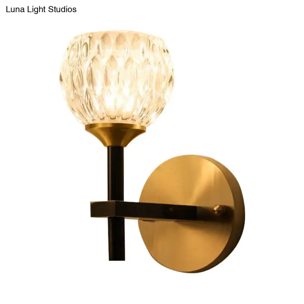 Modern black and gold wall light for living room with dimpled glass and brass-finished metal components
