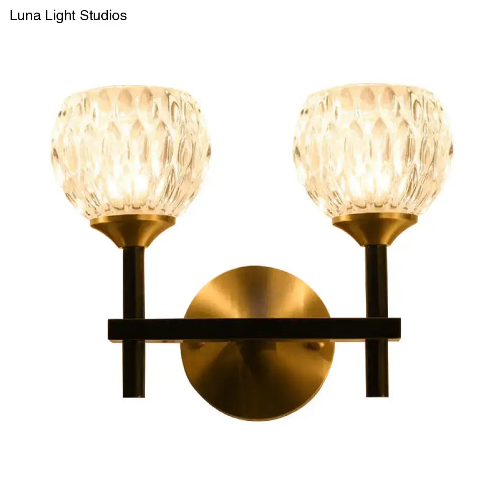 Brass-finished wall light with two faceted dimpled glass shades for stylish living room illumination