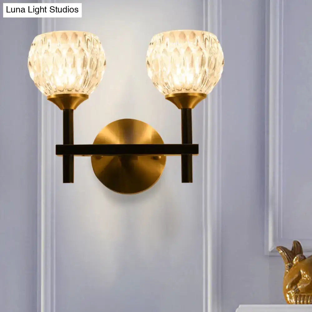 Modern brass-finished wall light with two textured dimpled glass shades for stylish living room lighting