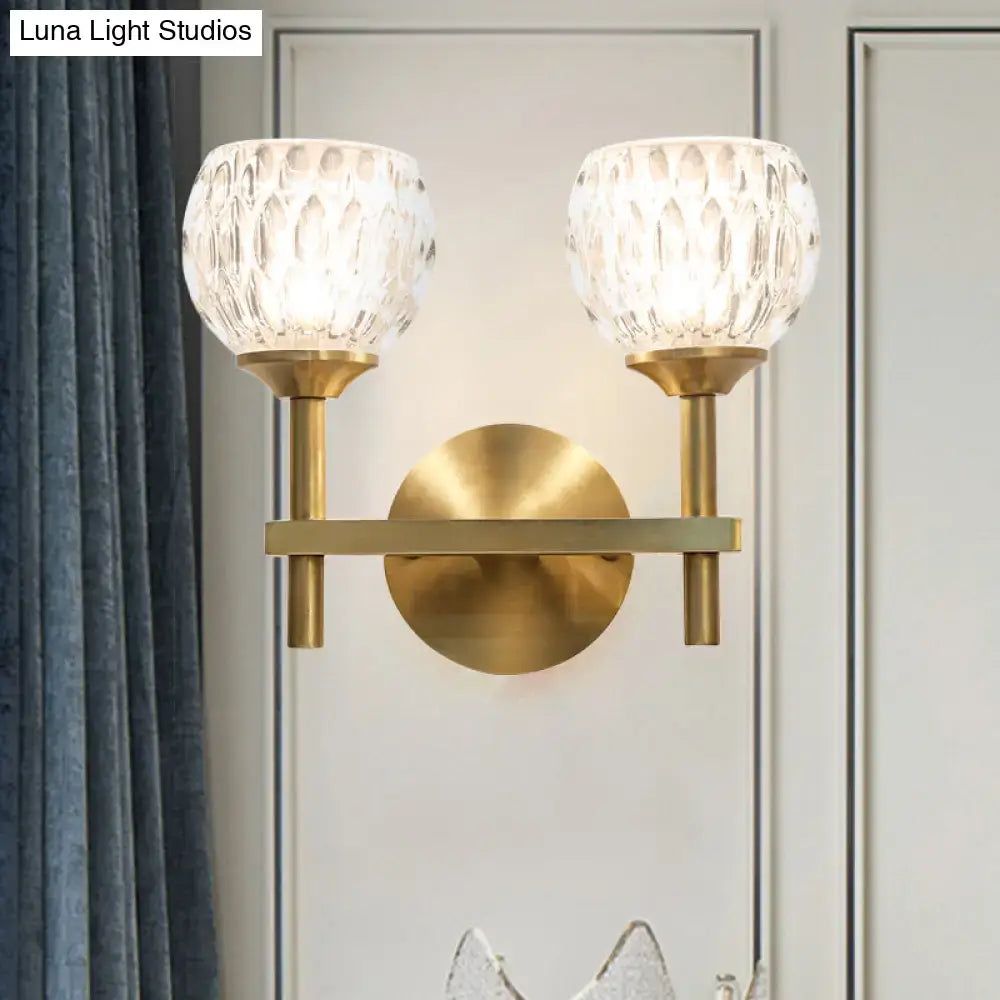 Brass-finished modern wall light with two textured dimpled glass globes for stylish living room lighting