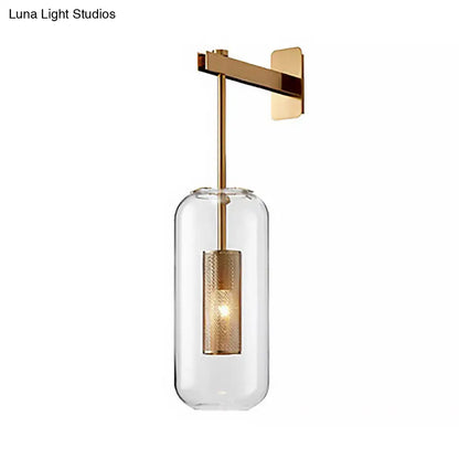 Modern gold-toned wall mounted light with clear glass shade and textured metallic inner cylinder for living room use