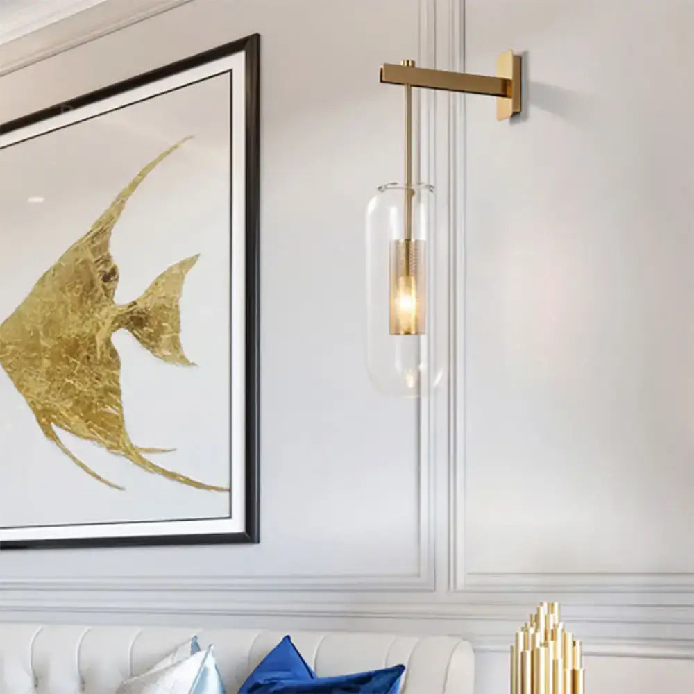 Modern black and gold wall mounted light featuring a gold-toned metal frame and clear glass cylinder housing bulb