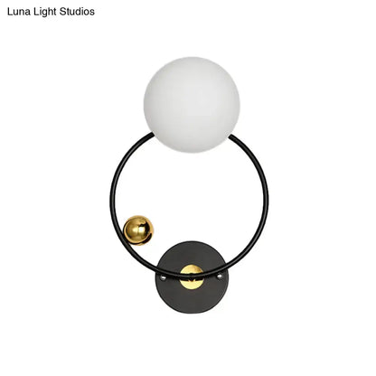 Modern black and gold wall sconce light with opal glass shade featuring matte white spherical glass and polished gold accents