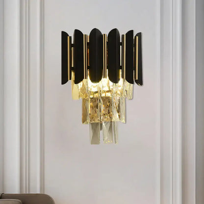Modern black and gold wall sconce with black finish and clear faceted crystals for bedroom lighting