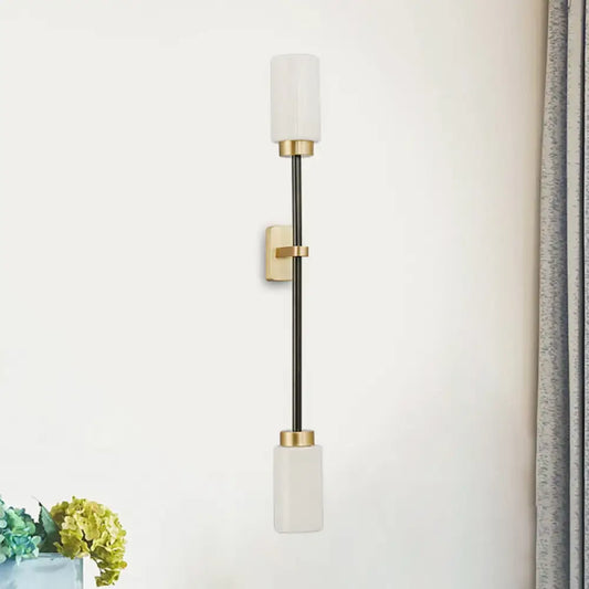 Modern black and gold wall sconce with white glass shade and frosted cylindrical glass for living room lighting